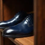 Navy blue leather shoes arranged on a wooden shelf