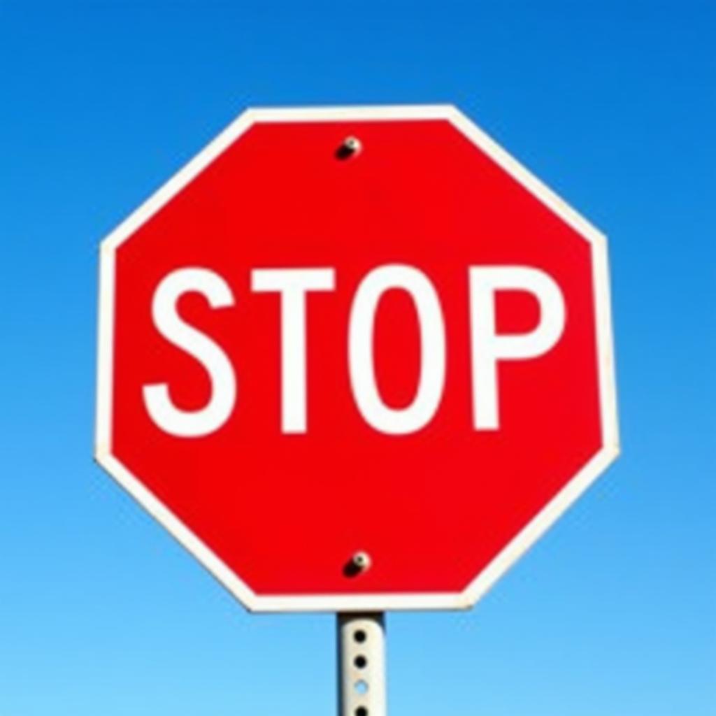 A red stop sign stands out against a blue sky.