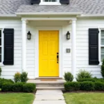 White house with black shutters and a yellow front door