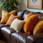 Warm toned pillows on a dark brown leather couch