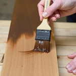 Applying wood stain with a brush