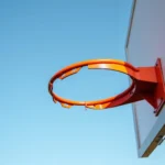 Orange basketball rim against blue sky