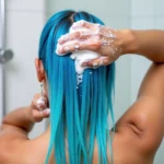 Woman washing blue hair with clarifying shampoo