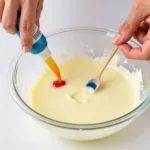 Adding oil-based food coloring to melted white chocolate