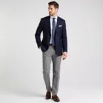 Man in navy blazer, gray pants, and brown shoes