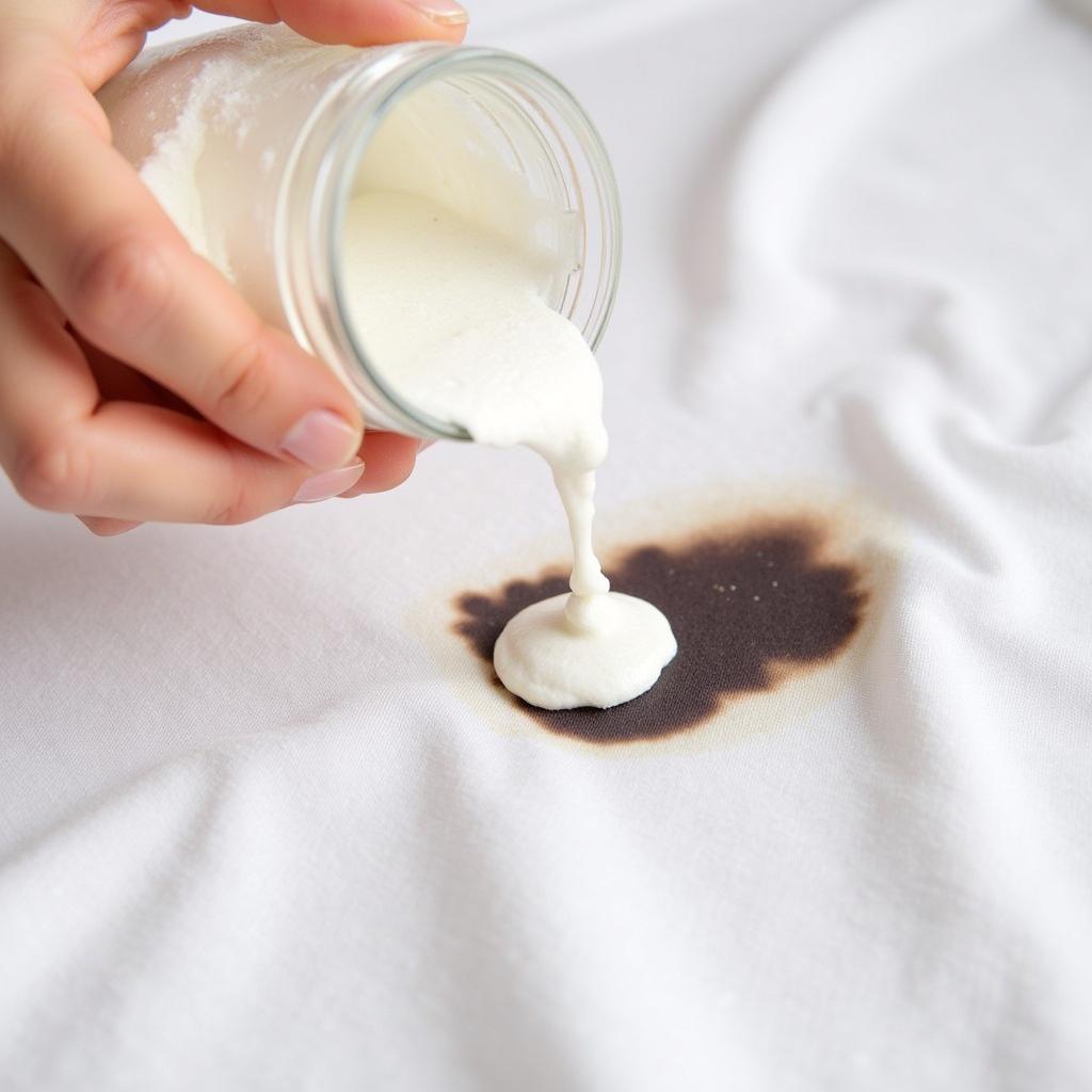 Applying Baking Soda Paste to a Color Stain on White Fabric